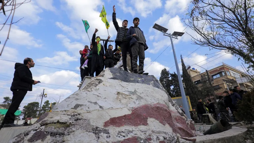 Syrians topple and trample on statues of Assad's father